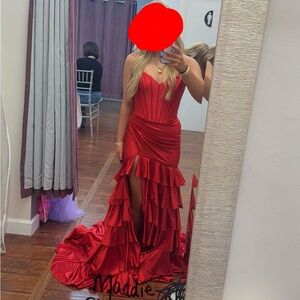 Strapless mermaid gown with corset bodice, lace up back and ruffle skirt slit.